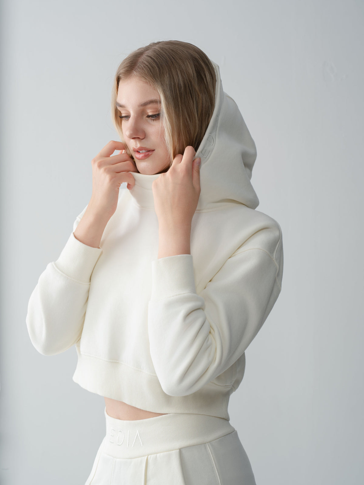 Model wearing the AEDIA Funnel Hoodie in Milk
