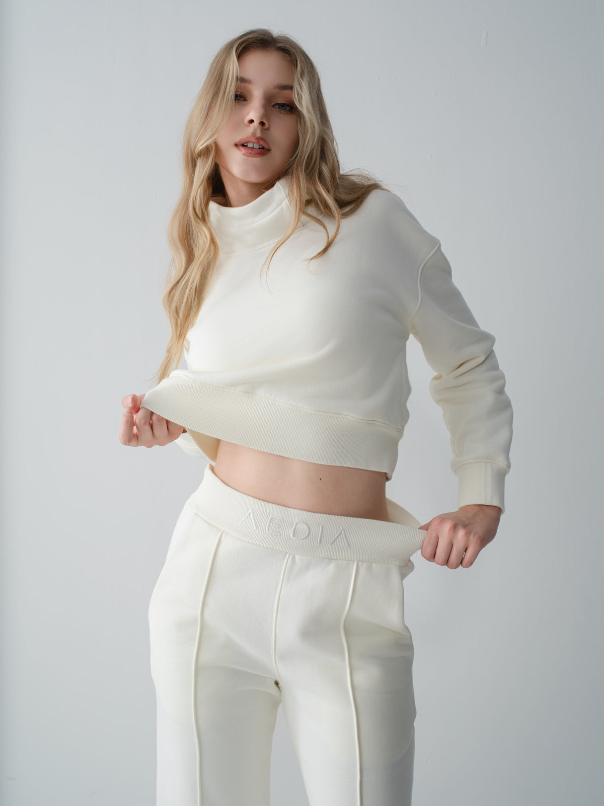 Model wearing the AEDIA Funnel Hoodie and Wide Leg Pants in Milk, fit detail